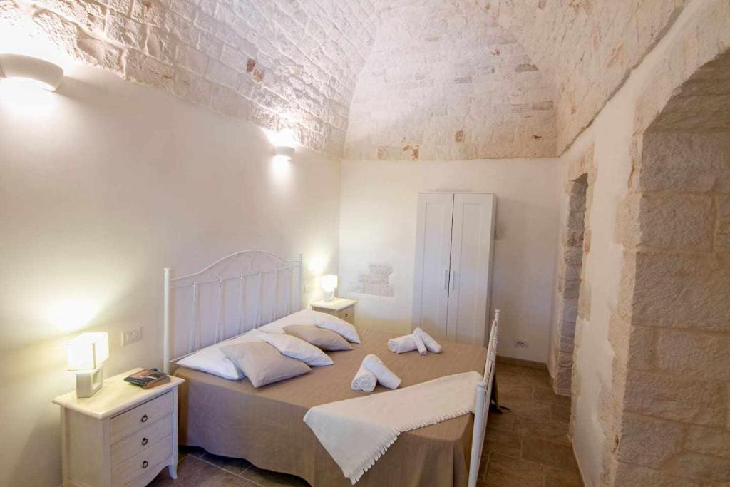 une chambre avec un lit avec deux oreillers dans l'établissement Villa Le Nacchere with exclusive pool, à Cisternino 35 autres photos