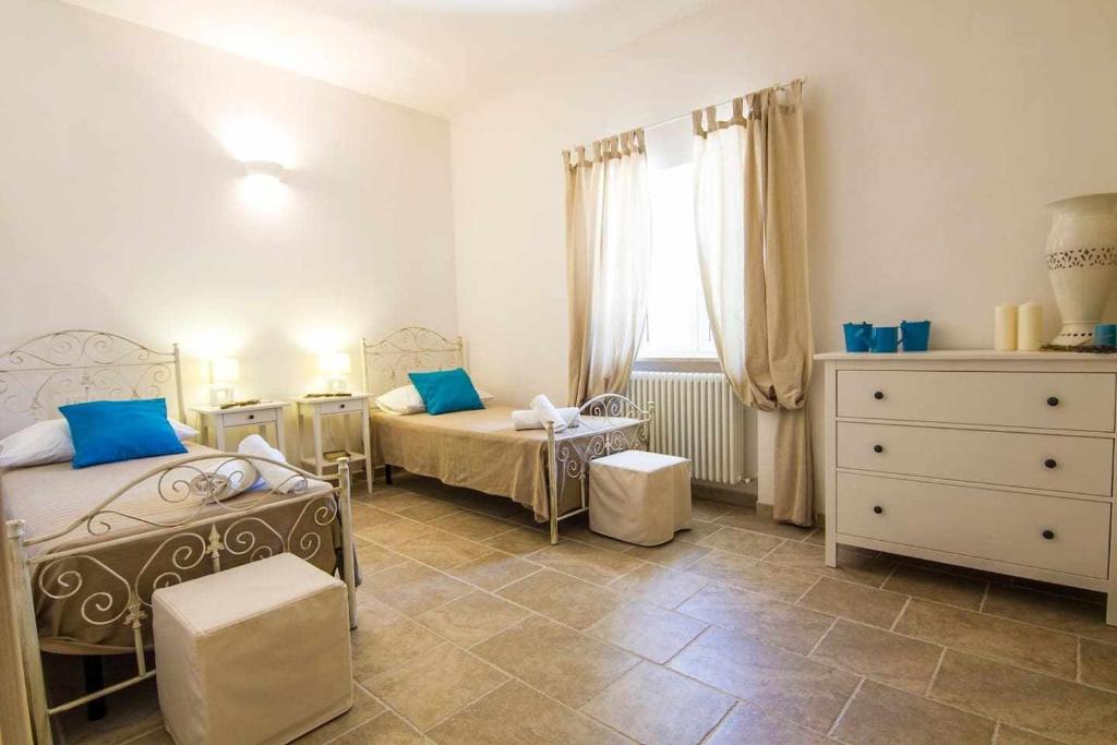 une chambre avec deux lits jumeaux et une commode dans l'établissement Villa Le Nacchere with exclusive pool, à Cisternino