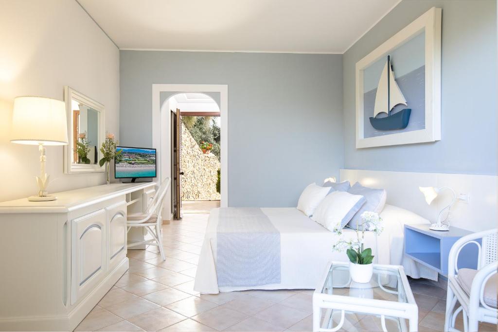 - une chambre avec un lit et une table avec une télévision dans l'établissement Hotel Baia di Nora, à Pula