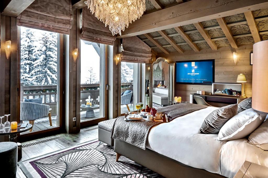 - une chambre avec un grand lit et une télévision dans l'établissement Lys Martagon, à Courchevel