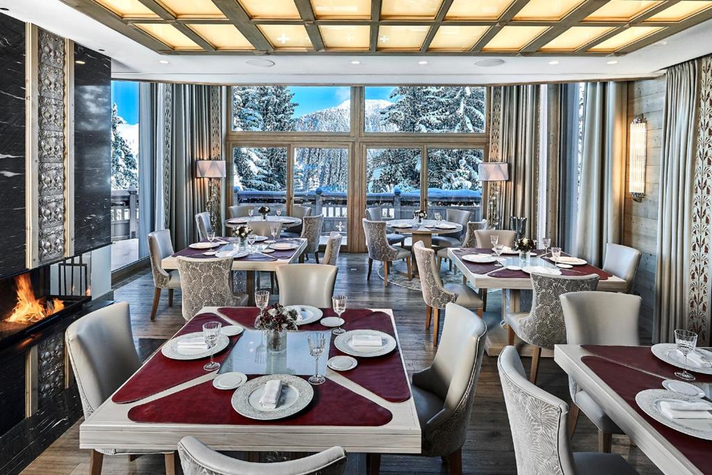 une salle à manger avec tables et chaises et une cheminée dans l'établissement Lys Martagon, à Courchevel