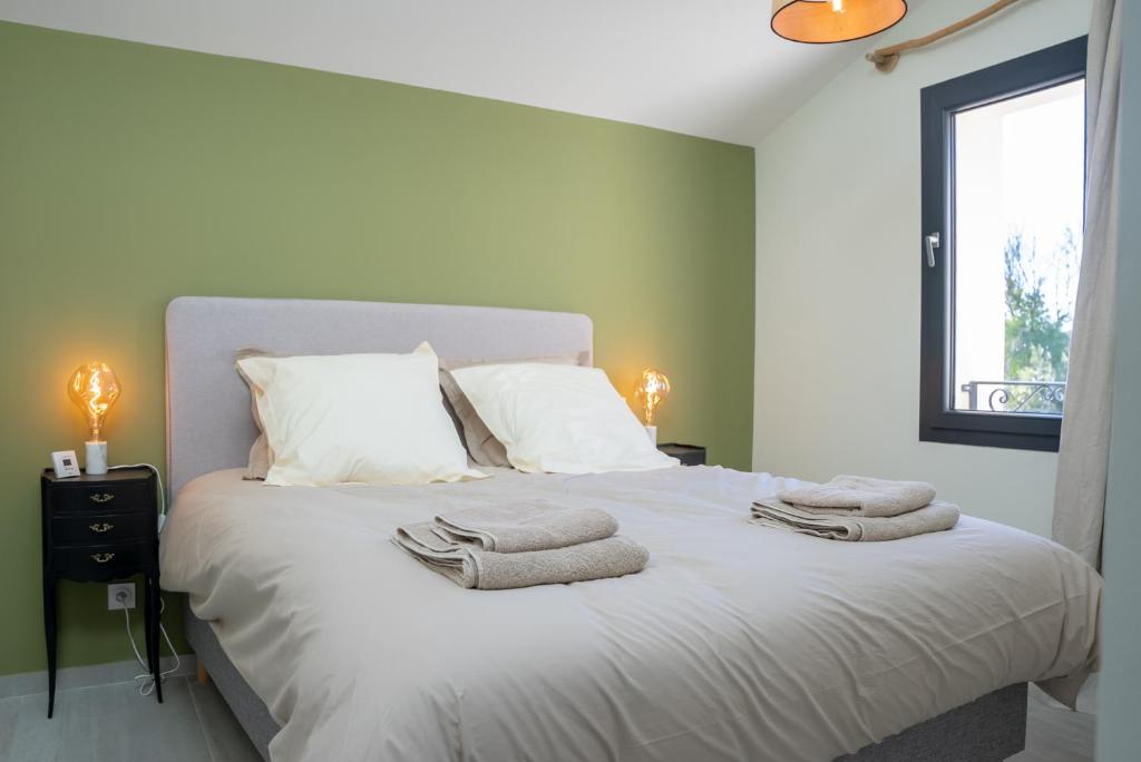 une chambre avec un grand lit blanc avec des serviettes dessus dans l'établissement Domaine de Mérins, 10 couchages avec piscine, face à la rivière, à 4km de la plage, à Fleury
