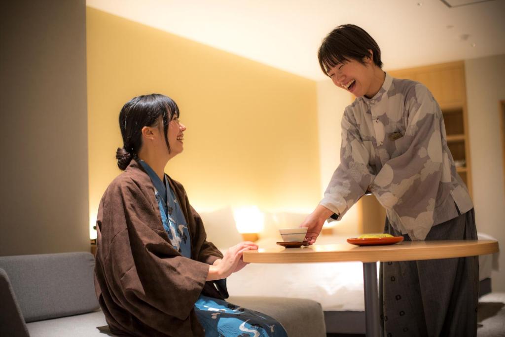 Un homme debout à côté d'une femme à une table dans l'établissement Hotel Kitanoya, à Miyazu 37 autres photos
