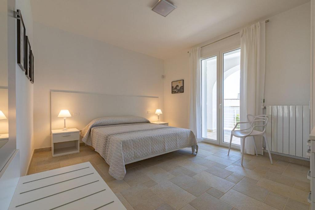 une chambre avec un lit et une grande fenêtre dans l'établissement Villa Arca - RivedelSalento, à Otrante