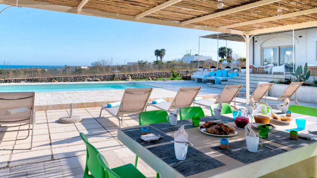 un patio avec une table et des chaises et une piscine dans l'établissement VILLA GIALONIA 8&2, Emma Villas, à Salve