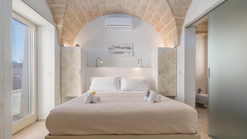 une chambre avec un grand lit blanc avec deux oreillers dans l'établissement VILLA GIALONIA 8&2, Emma Villas, à Salve 40 autres photos