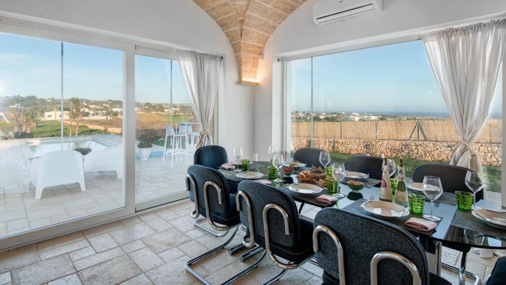 une salle à manger avec une table et des chaises et un balcon dans l'établissement VILLA GIALONIA 8&2, Emma Villas, à Salve