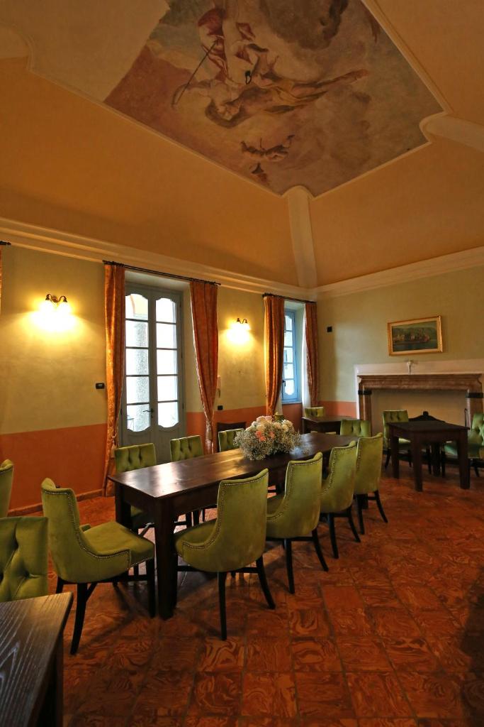 une salle à manger avec une table et des chaises vertes dans l'établissement Palazzo Del Vicerè, à Lezzeno