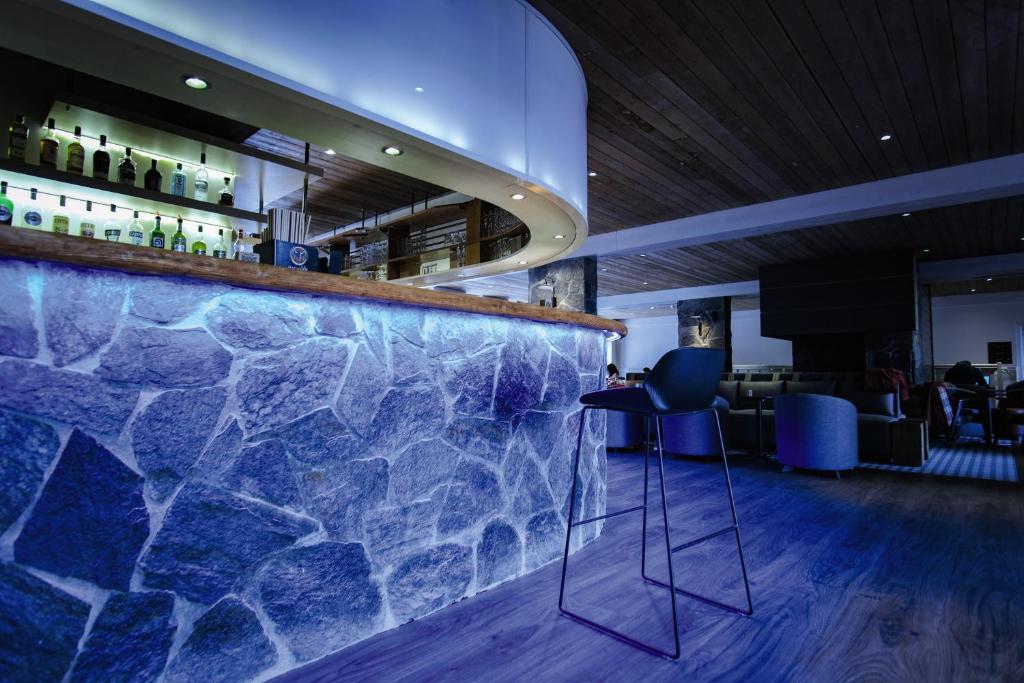- un bar dans une pièce dotée d'un mur en pierre dans l'établissement Belambra Clubs Arc 1800 - Hôtel Du Golf, à Arc 1800 26 autres photos