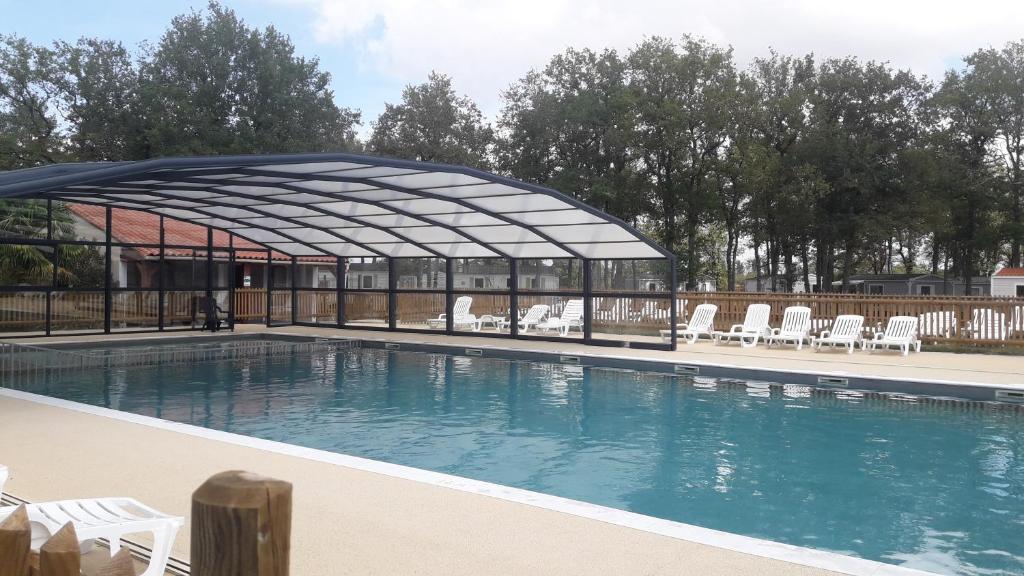 - une piscine avec un pavillon et des chaises dans l'établissement Mobil Home camping 3*** piscine chauffée, à La Boissière-de-Montaigu