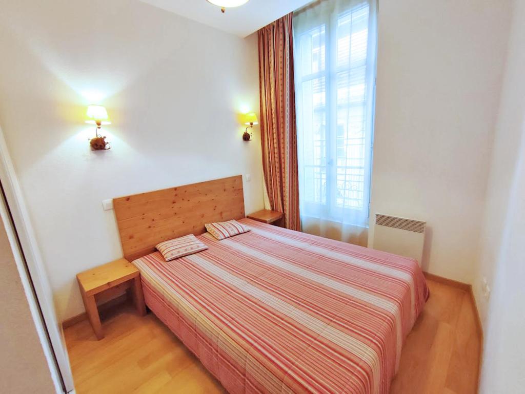 une petite chambre avec un lit et une fenêtre dans l'établissement La petite ourse, T2, centre Luchon, wifi, casier à skis, ascenseur, 4 personnes, à Luchon