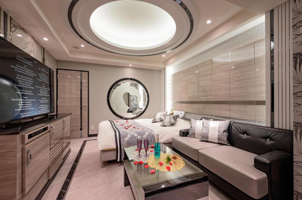 une chambre d'hôtel avec un lit, un canapé et une télévision dans l'établissement Hotel Moana Shinjuku (Adult Only), à Tokyo