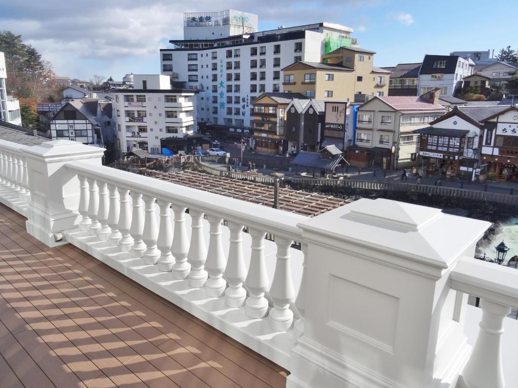 - un balcon blanc avec vue sur la ville dans l'établissement Hotel Ichii, à Kusatsu
