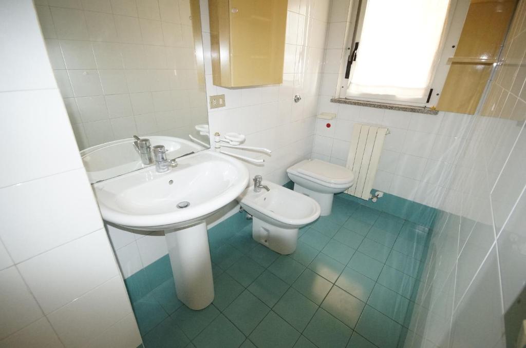 une salle de bain avec un lavabo et des toilettes dans l'établissement Appartamenti La Mer, à San Benedetto del Tronto 10 autres photos