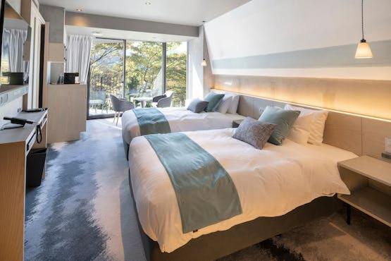 Cet appartement comprend une chambre avec deux lits et une cuisine. dans l'établissement HAKONE NICA, à Hakone