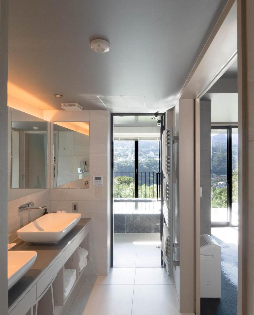 une salle de bain avec deux lavabos et un grand miroir dans l'établissement HAKONE NICA, à Hakone