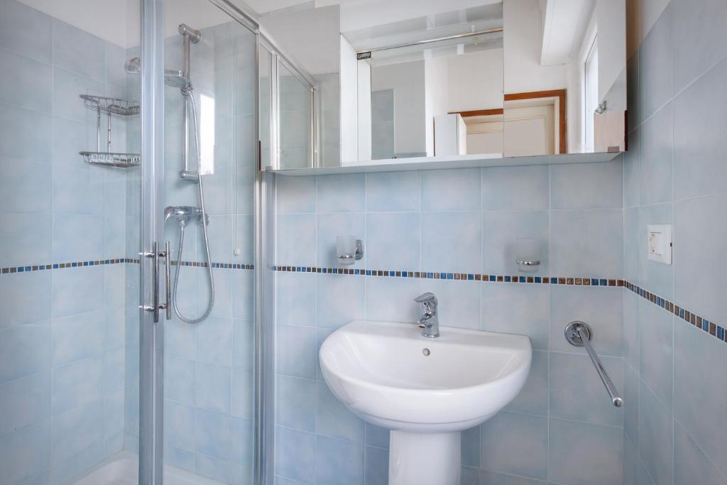 une salle de bain avec un lavabo blanc et une douche dans l'établissement Villa Belvedere-Con piscina a Bardolino, à Costermano