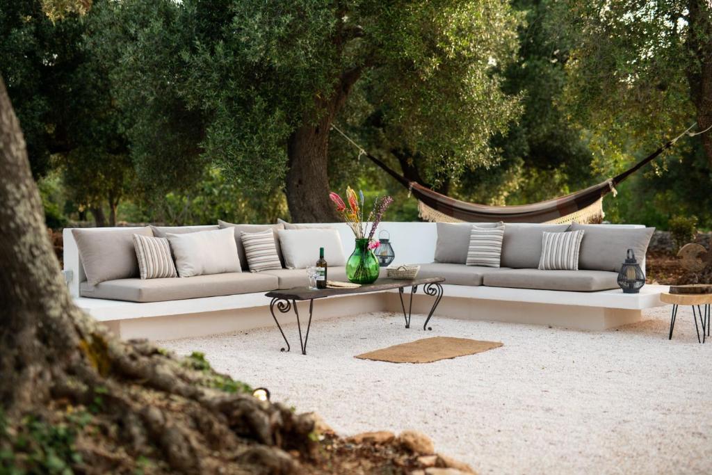 - un canapé blanc et une table basse dans un parc dans l'établissement TRULLO TIPOTA with private pool, à Ceglie Messapica