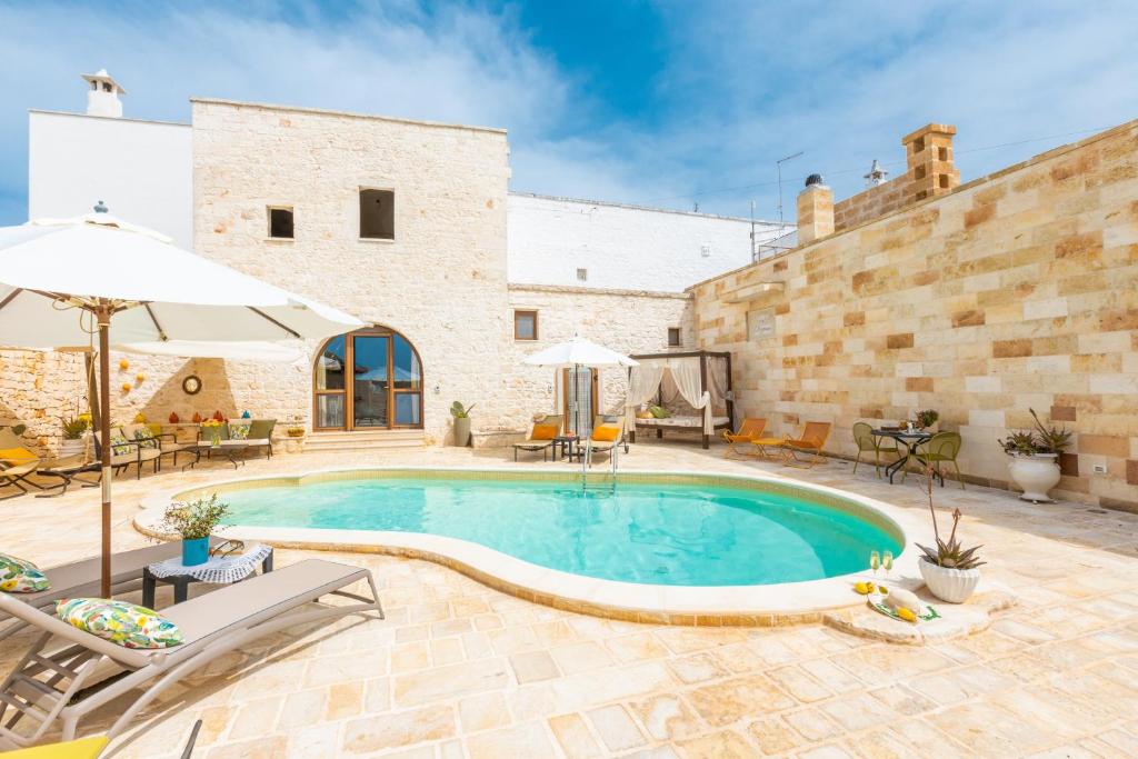 - une piscine au milieu d'une cour avec un bâtiment dans l'établissement Casale Citrignano with Pool, à Ostuni