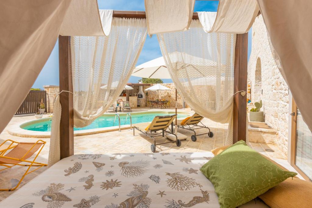 - une chambre avec un lit et une piscine dans l'établissement Casale Citrignano with Pool, à Ostuni