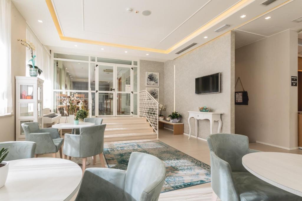 un restaurant avec des tables et des chaises et un escalier dans l'établissement Hotel Principe, à Cattolica