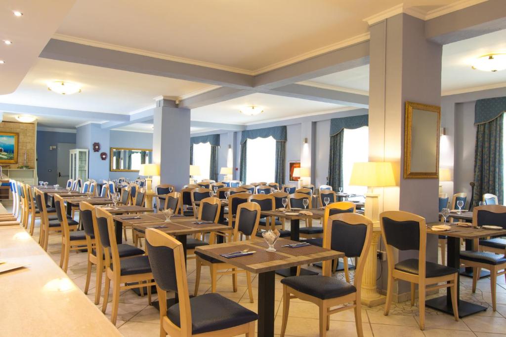 une salle à manger avec des tables et des chaises en bois dans l'établissement Conchiglia Azzurra Resort & Beach, à Porto Cesareo