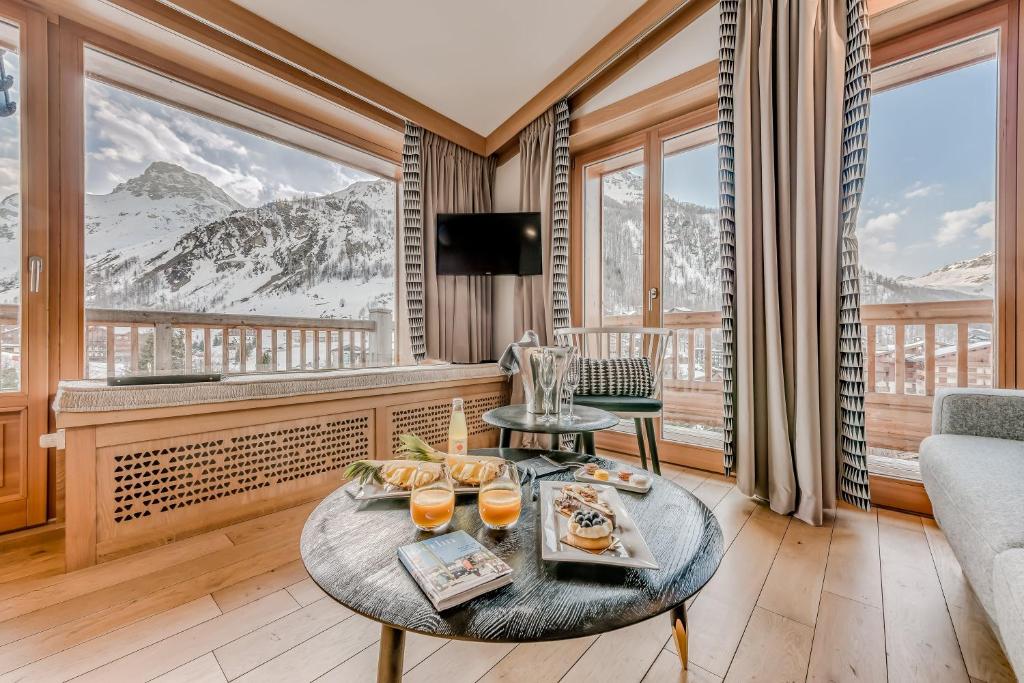 un salon avec une table avec de la nourriture dessus dans l'établissement Le Yule Hotel & Spa, à Val dʼIsère
