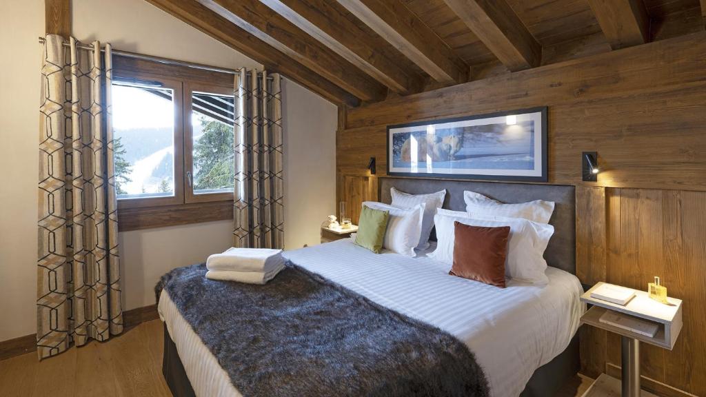 une chambre avec un grand lit et une fenêtre dans l'établissement MGM Hôtels & Résidences - Résidence Amaya, à Villard-sur-Doron 37 autres photos
