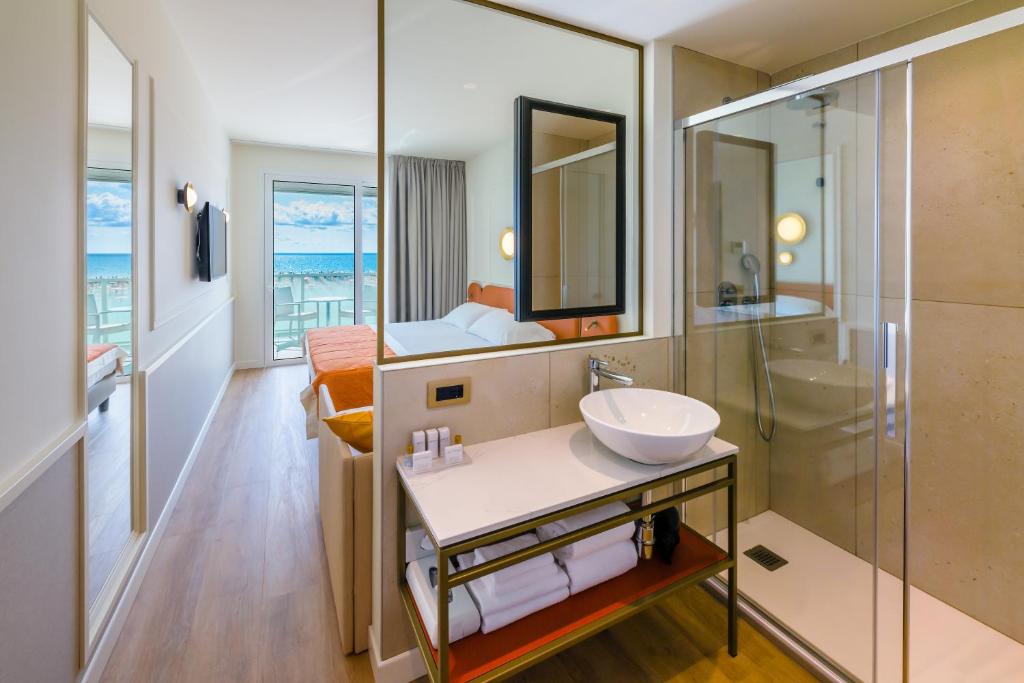 une salle de bain avec un lavabo et une douche dans l'établissement Hotel Montecarlo, à Bibione