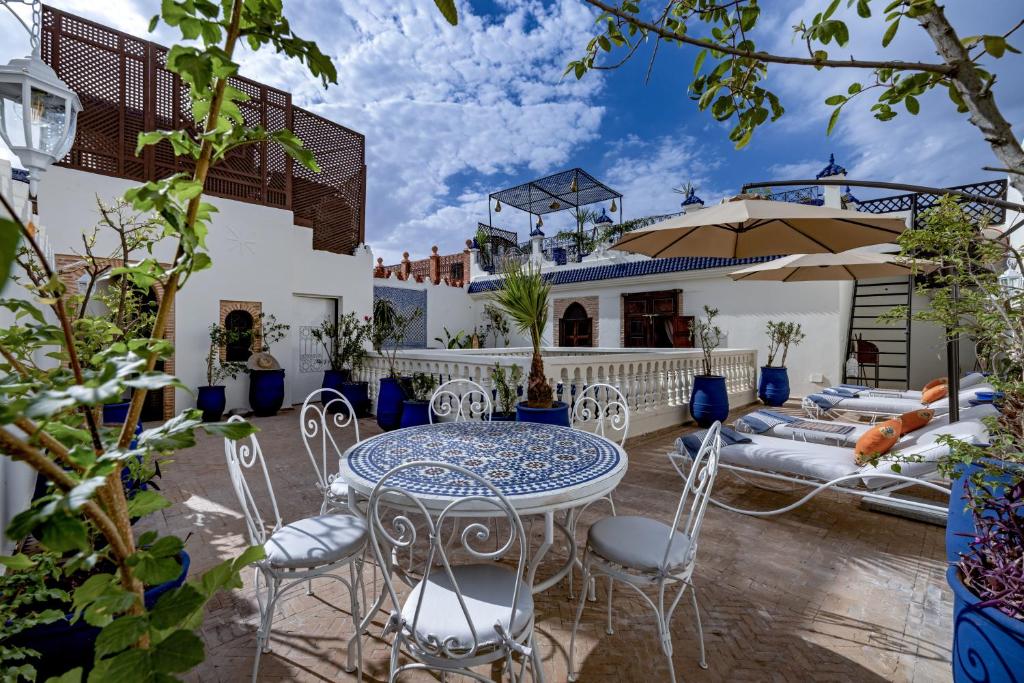 une terrasse avec une table et des chaises ainsi qu'une maison dans l'établissement Maïpa Boutique Riad, à Marrakech