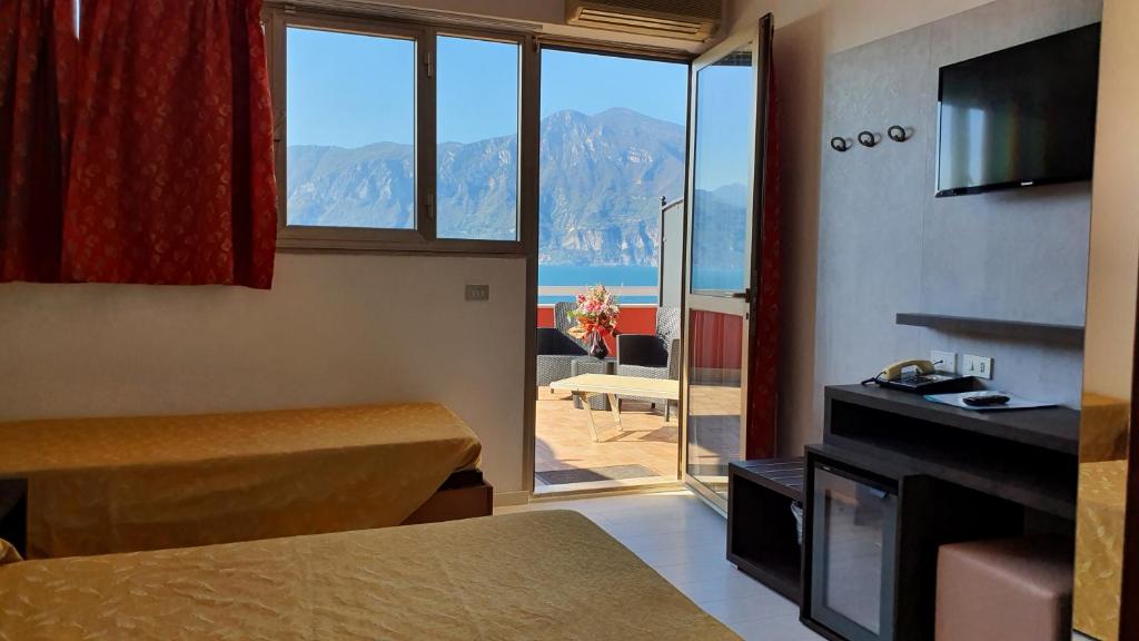 une chambre d'hôtel avec vue sur l'océan et les montagnes dans l'établissement Hotel Merano, à Brenzone