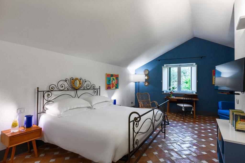 une chambre avec un lit blanc et un mur bleu dans l'établissement Relais Regina Giovanna, à Sorrente