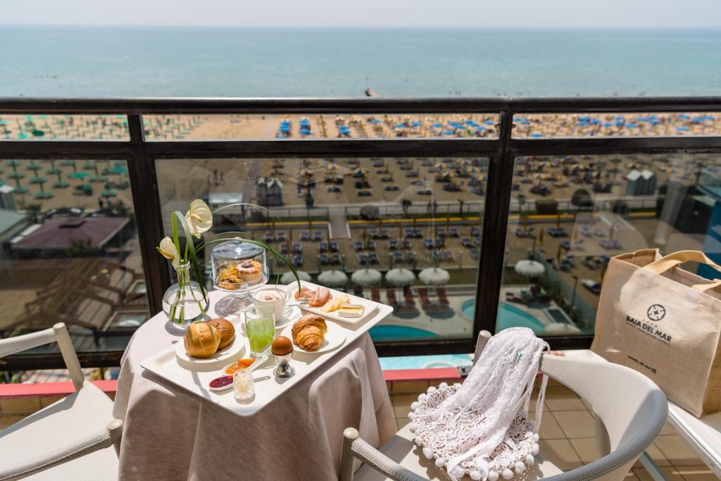 - une table avec de la nourriture et une vue sur l'océan dans l'établissement Baia del Mar Beach Boutique Hotel, à Lido di Jesolo