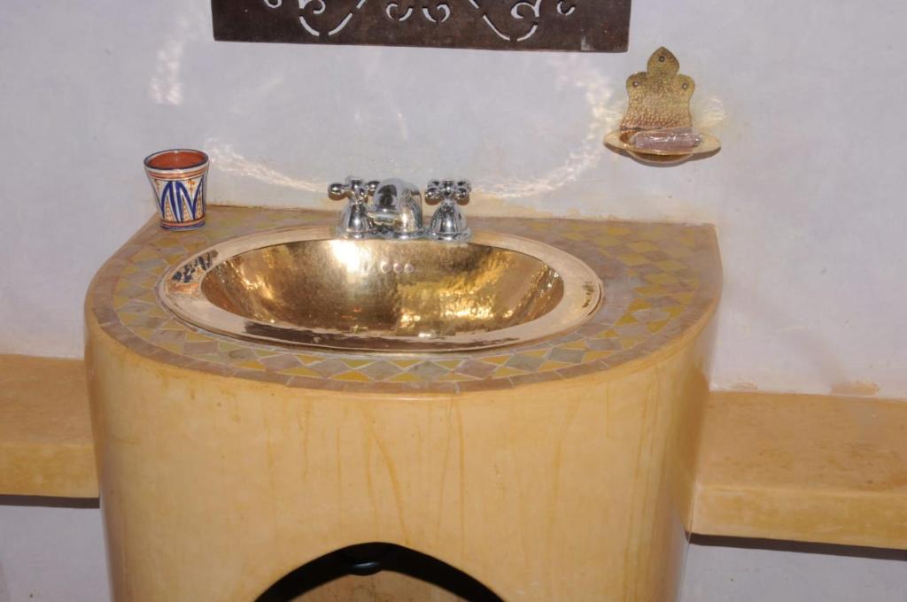 La salle de bains est pourvue d'un lavabo sur un comptoir en bois. dans l'établissement Ksar Jenna, à Nkob