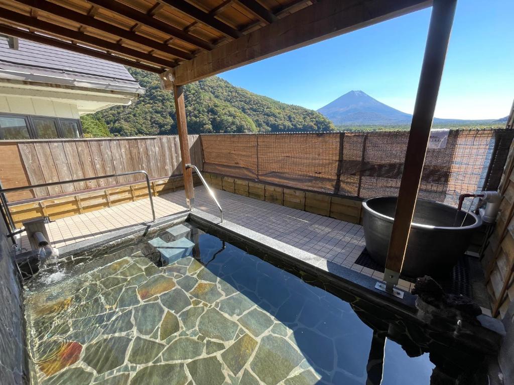 - une piscine avec une baignoire et une vue sur la montagne dans l'établissement Shoji Lake Hotel, à Fujikawaguchiko 33 autres photos