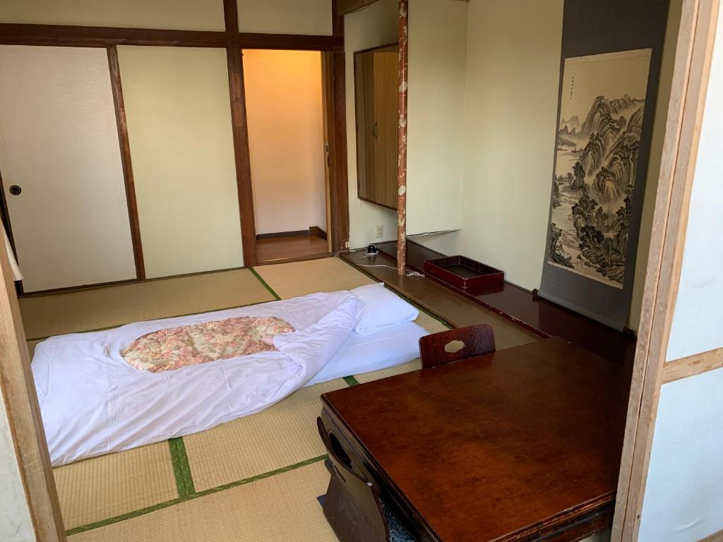 une pièce avec un lit et une table dedans dans l'établissement Beppu no Oyado Kagaya, à Beppu