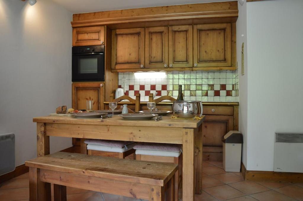 une cuisine avec des armoires en bois et une table en bois dans l'établissement 2 bedroom Apartment in Les Houches Stone's throw from Prairon lift, aux Houches 14 autres photos