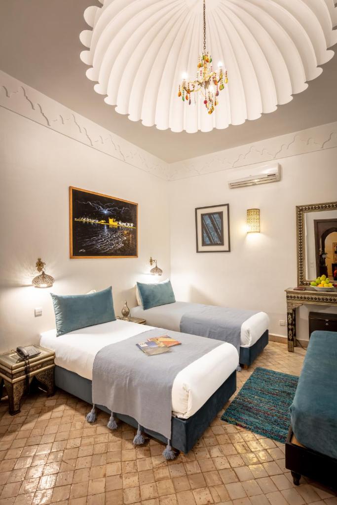 une chambre avec deux lits et un lustre dans l'établissement Riad & Spa Bahia Salam, à Marrakech 37 autres photos