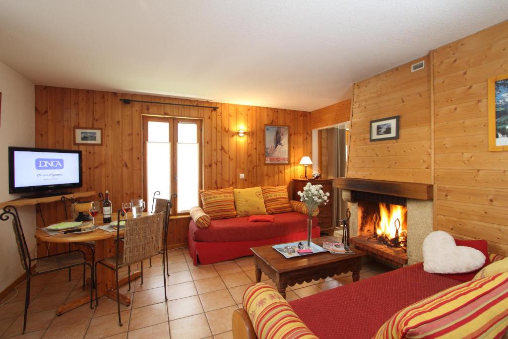 un salon avec un canapé et une cheminée dans l'établissement Locations Cosy - Village Piéton avec Vue Glaciers - chez Philippe, à La Grave 37 autres photos