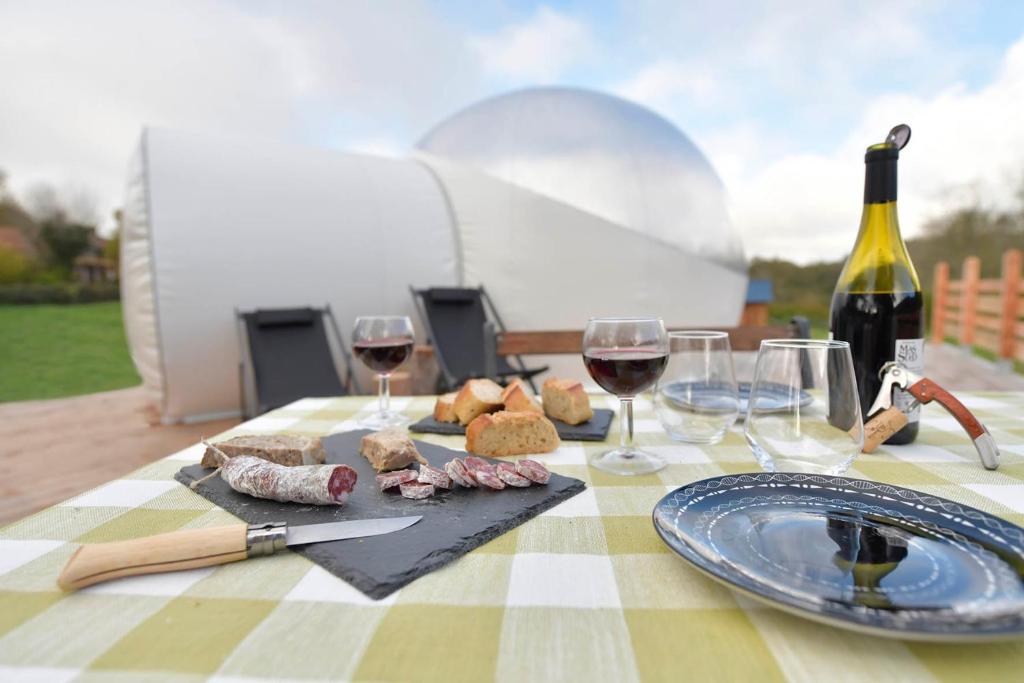 - une table avec des verres de vin et de la nourriture dans l'établissement Bulle Ecureuil, à Quarré-les-Tombes