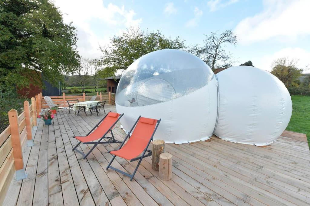 deux dômes blancs assis sur une terrasse avec deux chaises dans l'établissement Bulle Hirondelle, à Quarré-les-Tombes