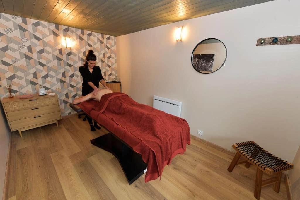 une femme est assise sur un lit dans une pièce dans l'établissement Bulle Hirondelle, à Quarré-les-Tombes