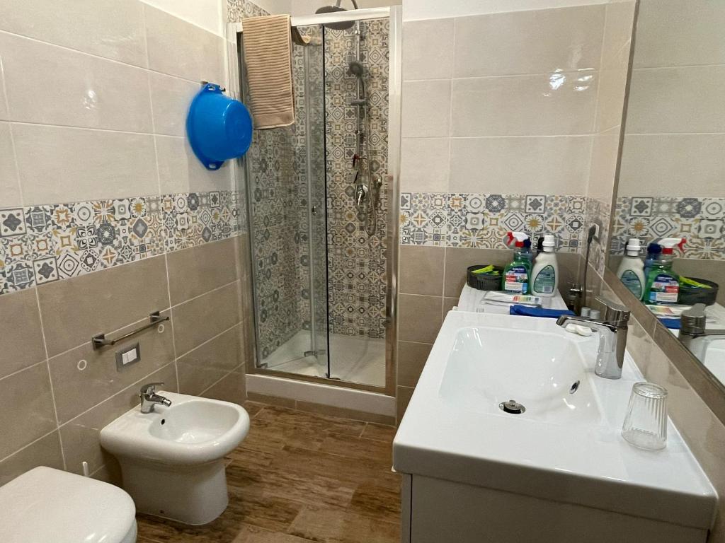 une salle de bain avec un lavabo, une douche et des toilettes dans l'établissement Le Sirene Casa Vacanza, à Torvaianica