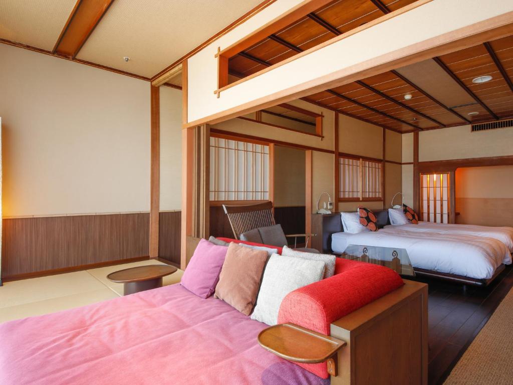 une chambre d'hôtel avec deux lits et un canapé dans l'établissement Awaji Yumesenkei, à Sumoto