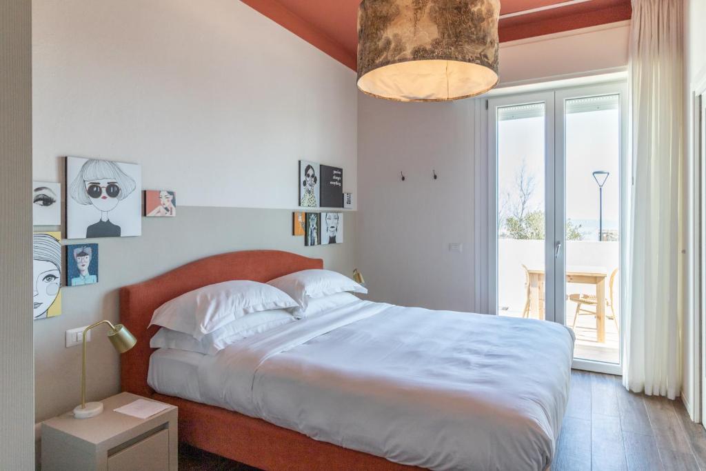 une chambre avec un grand lit et une grande fenêtre dans l'établissement Lu. b&b, à Cervia