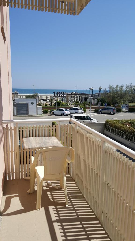 un banc sur un balcon avec vue sur la rue dans l'établissement Residence Summer Dream, à Cervia