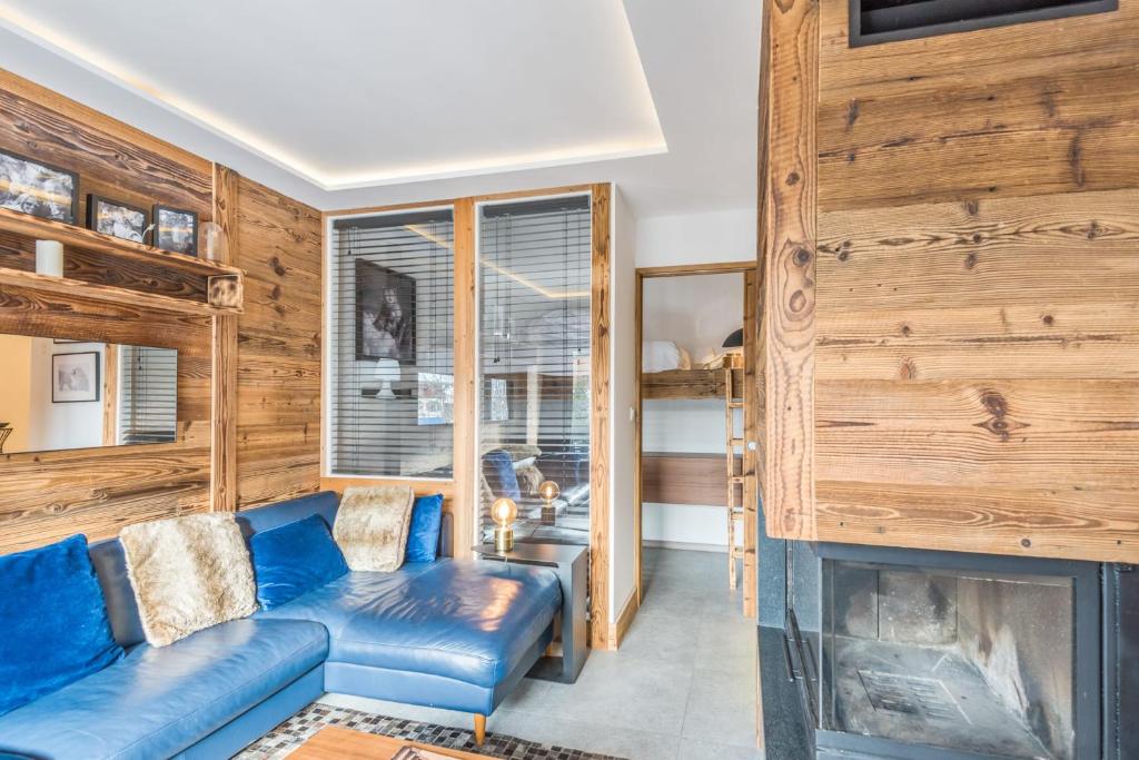 un salon avec un canapé bleu et une cheminée dans l'établissement Appartement Perchets - Welkeys, à Megève