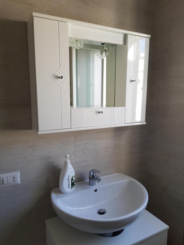 une salle de bain avec un lavabo blanc et un miroir dans l'établissement La Rotonda Sul Mare, à Vieste