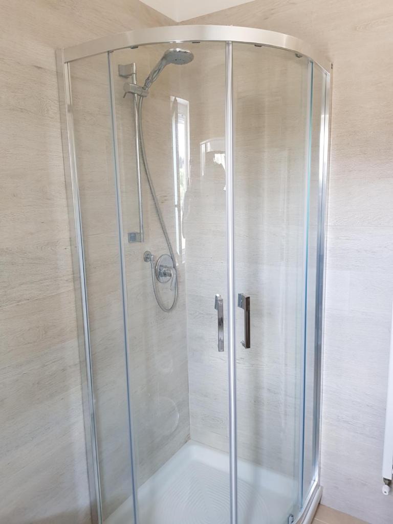 une douche avec une porte vitrée dans une salle de bain dans l'établissement La Rotonda Sul Mare, à Vieste