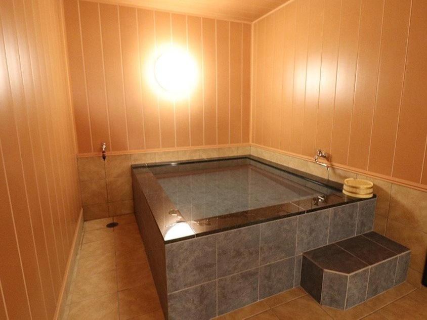 Cette chambre dispose d'une baignoire avec une lumière sur le mur. dans l'établissement Umino Hotel Hajime, à Beppu 35 autres photos
